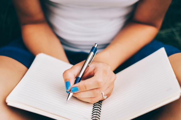 Woman writing 4 disciplines to improve execution of goals