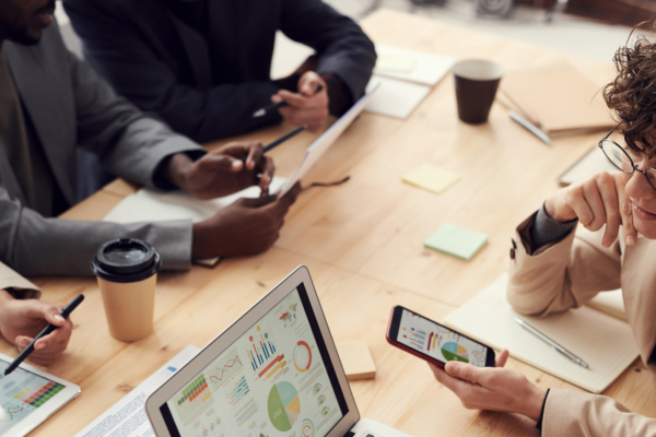 Effective teamwork between four people sitting at a table with computers